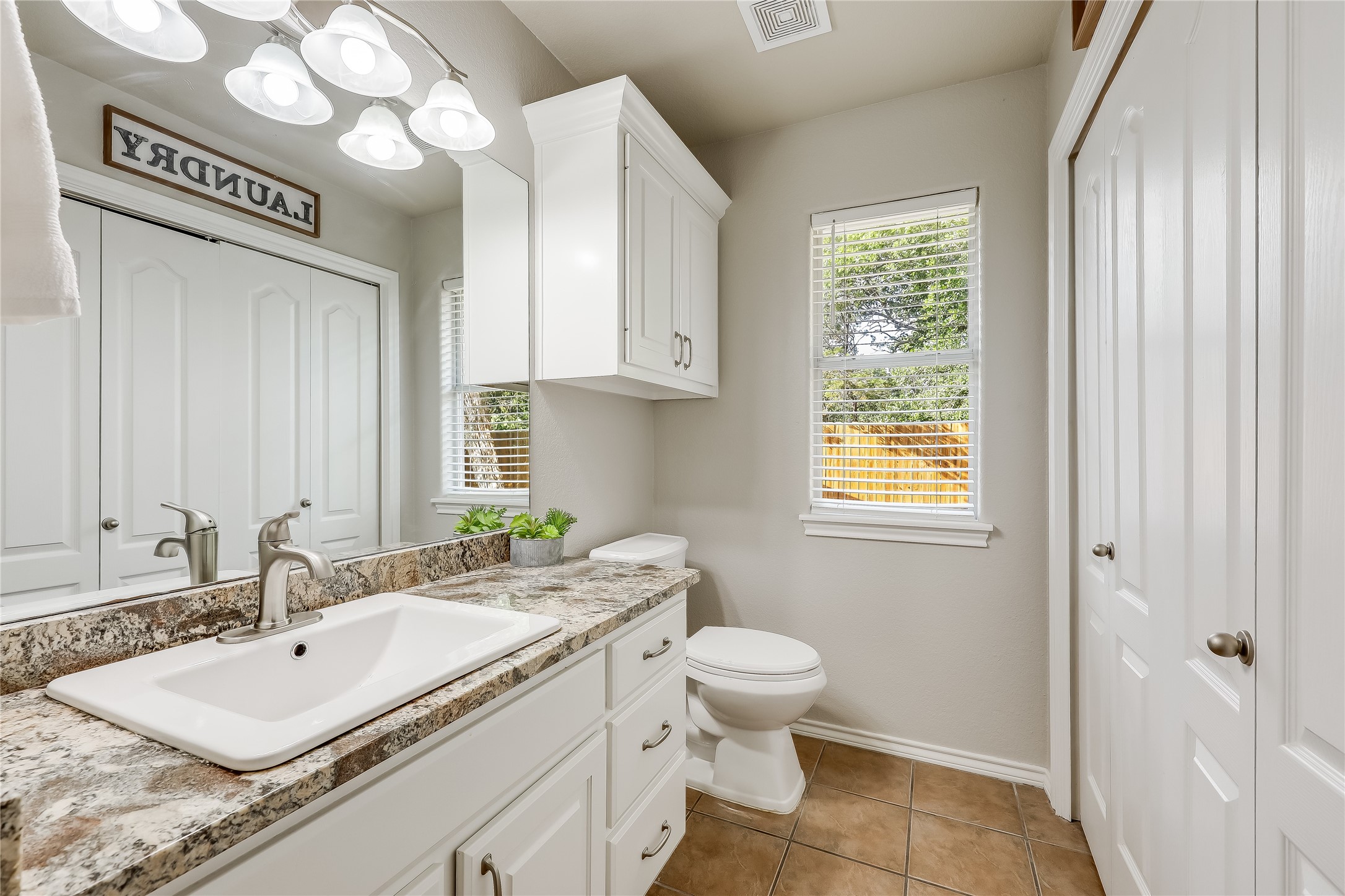 426 Summit Ridge Drive North Point Venture, TX 78645 - Photo 18 of 28 a bathroom with a granite countertop sink a toilet and a mirror