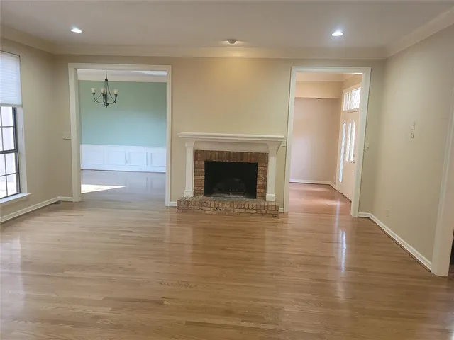 an empty room with wooden floor and a fireplace