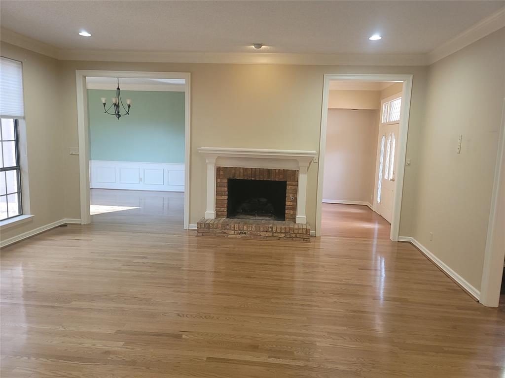 5719 Encore Drive Dallas, TX 75240 - Photo 11 of 21 an empty room with wooden floor and a fireplace