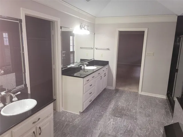 a spacious bathroom with a granite countertop sink a mirror and a shower