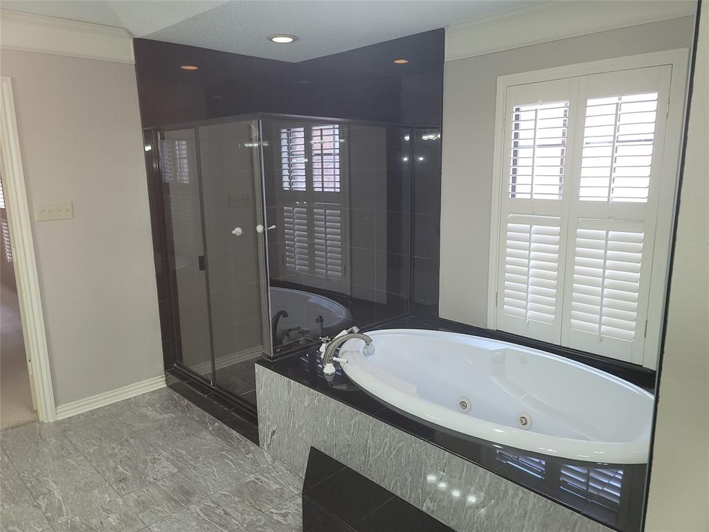 5719 Encore Drive Dallas, TX 75240 - Photo 17 of 21 a bathroom with a bathtub and a shower