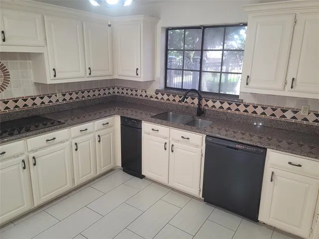 a kitchen with granite countertop white cabinets and white appliances