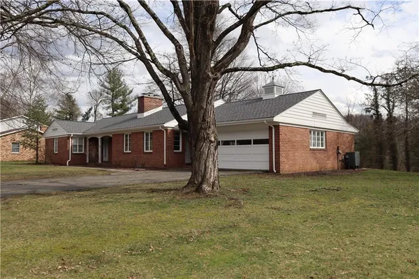 a view of a yard in front of a house with large tree
