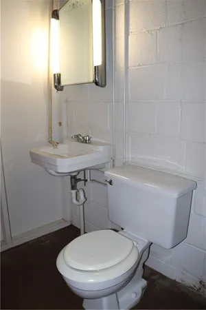 a bathroom with a sink mirror and toilet