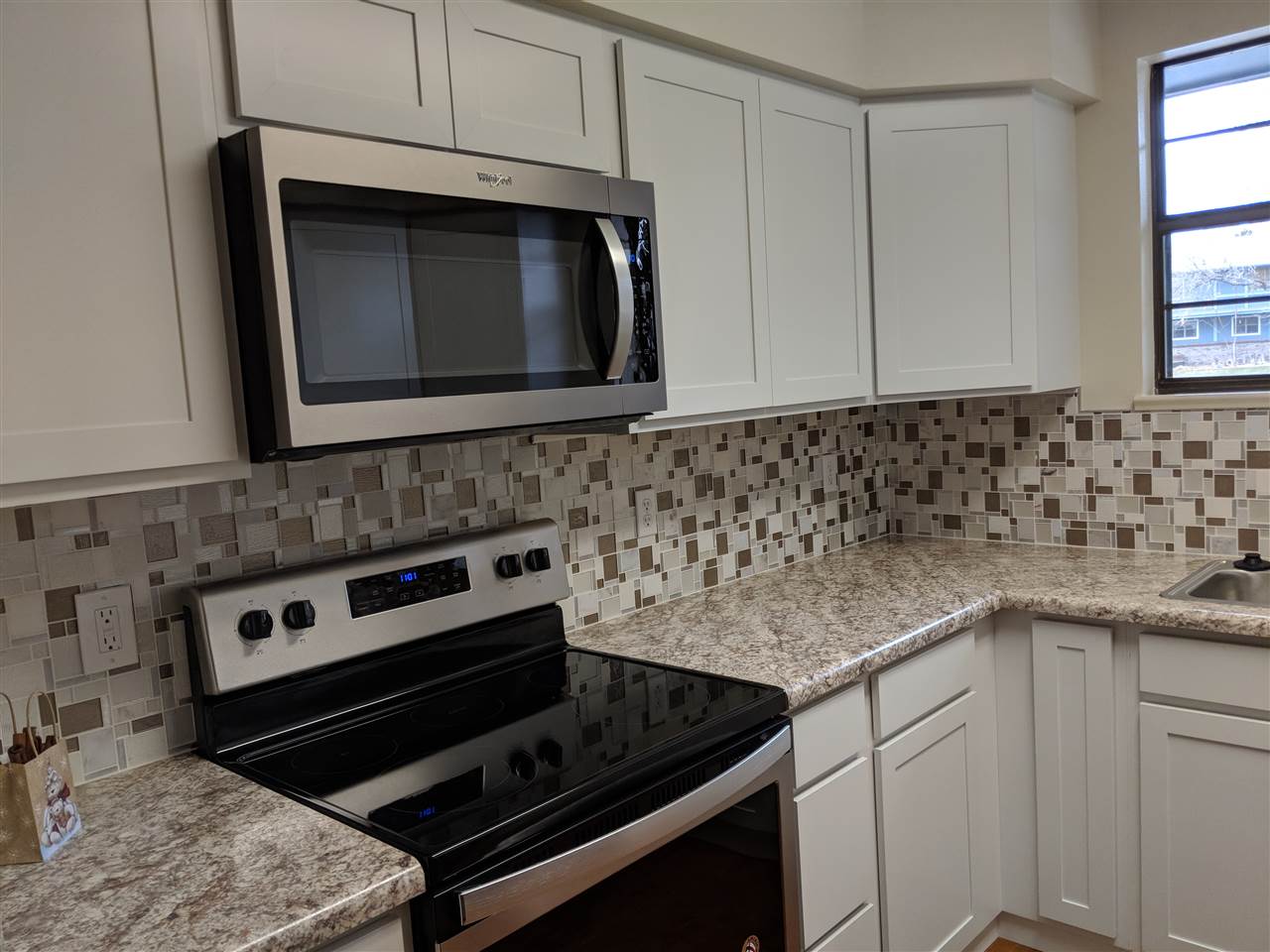 2721 Patterson Road, Unit 303 Grand Junction, CO 81506 - Photo 4 of 20 a kitchen with granite countertop a stove microwave and sink