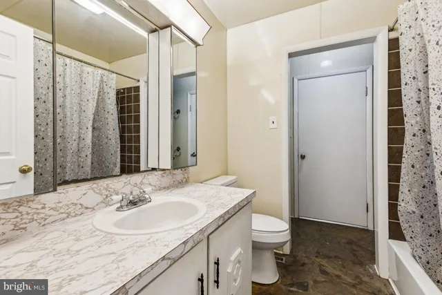 a bathroom with a granite countertop sink toilet and shower