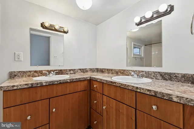 a bathroom with a granite countertop sink and a mirror