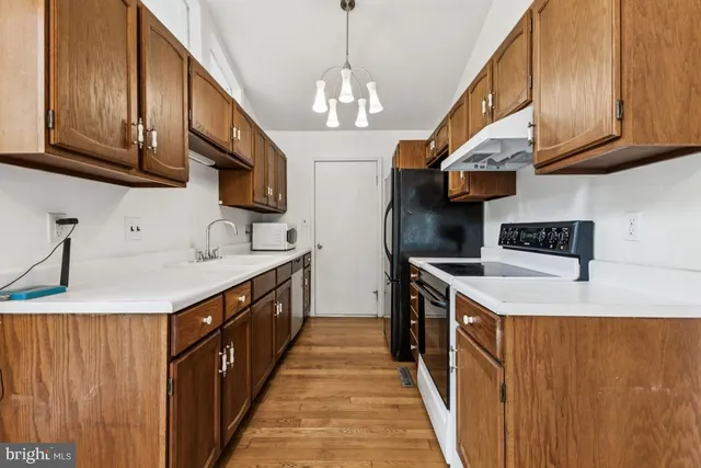 a kitchen with stainless steel appliances granite countertop a sink a stove and a wooden floors