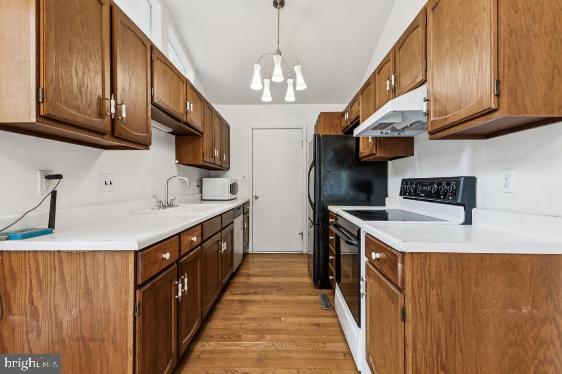 135 Lizzie Mills Road Castleton, VA 22716 - Photo 7 of 33 a kitchen with stainless steel appliances granite countertop a sink a stove and a wooden floors