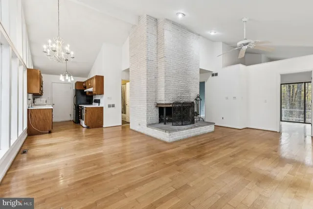 a view of a livingroom with a fireplace a chandelier and wooden floor