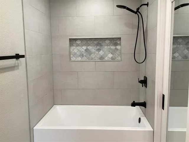 a bathroom with a bath tub with a shower