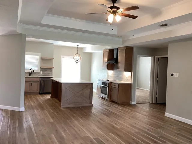 a large kitchen with stainless steel appliances kitchen island a large counter space a sink and cabinets