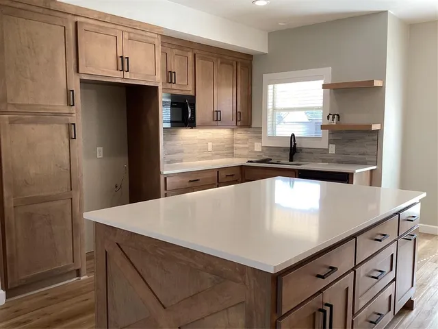 a kitchen with kitchen island a sink stove and refrigerator