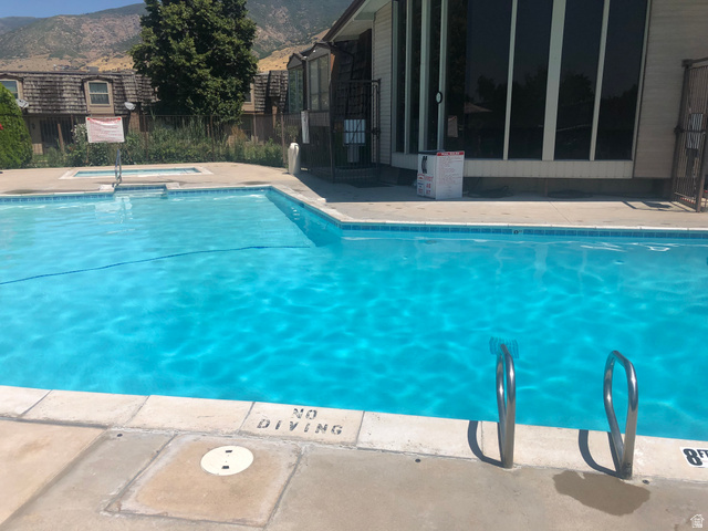 88 West 50 South, Unit B5 Centerville, UT 84014 - Photo 31 of 33 Community pool with a community hot tub, a mountain view, and a patio area