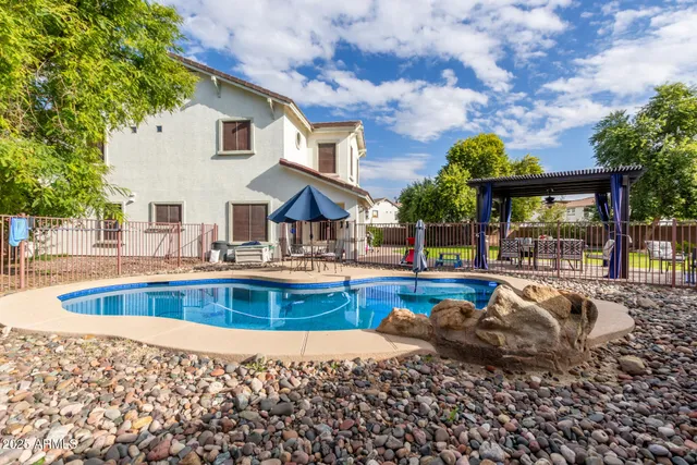 a view of a house with swimming pool and sitting area