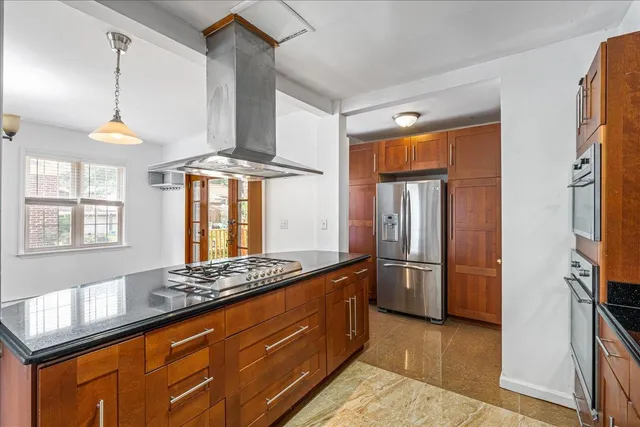 a kitchen with stainless steel appliances granite countertop a refrigerator a stove and a sink with wooden floor