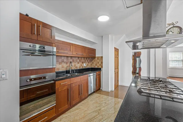 a kitchen with stainless steel appliances granite countertop a stove and a refrigerator