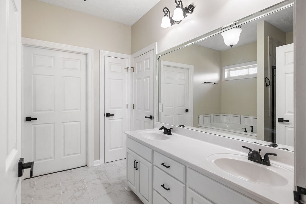 6502 Franklin Road Murfreesboro, TN 37128 - Photo 9 of 36 a bathroom with a double vanity sink mirror and shower
