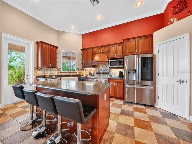 a kitchen with stainless steel appliances granite countertop a sink and a refrigerator