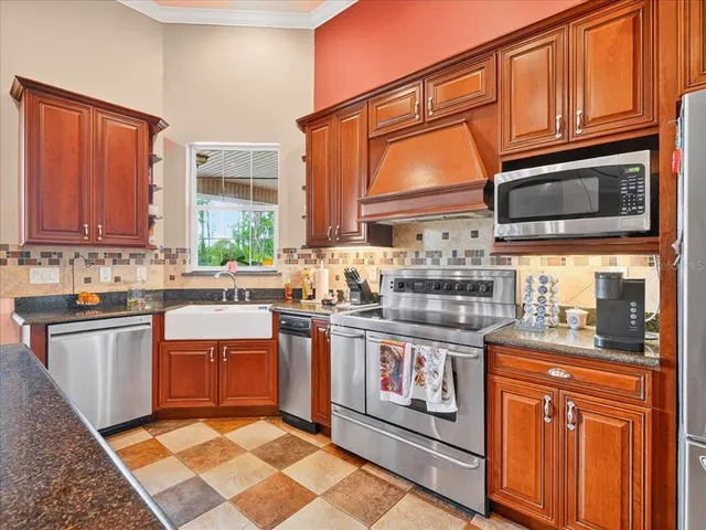 a large kitchen with stainless steel appliances granite countertop a stove a sink and a refrigerator