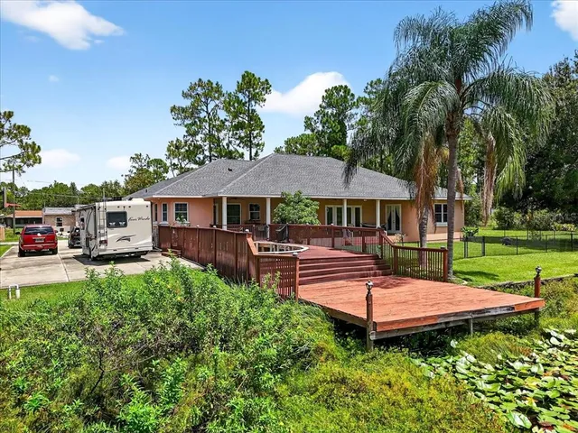 an aerial view of residential houses with outdoor space and trees