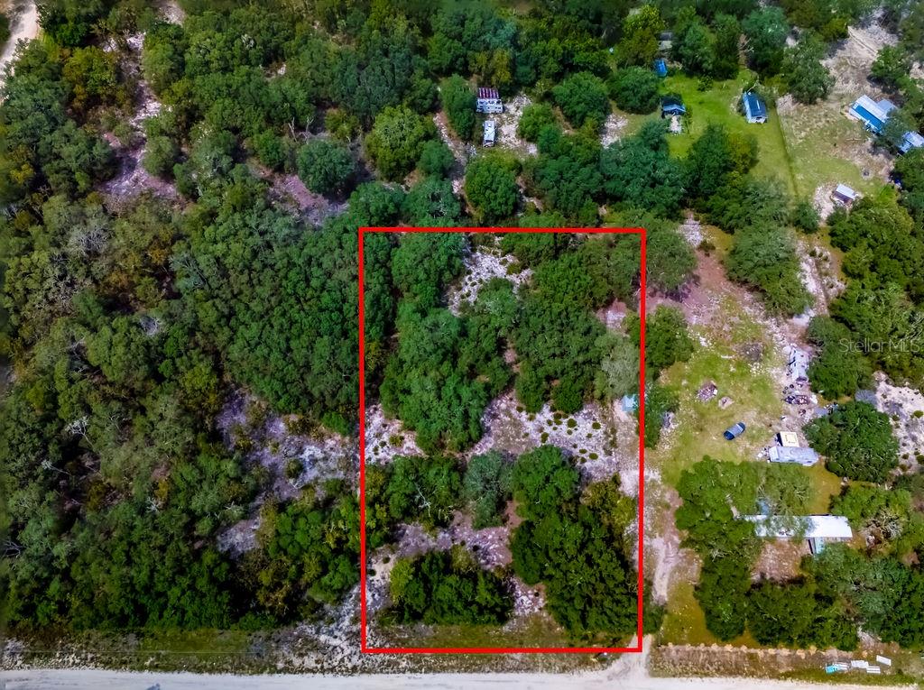 an aerial view of residential house with outdoor space and trees all around