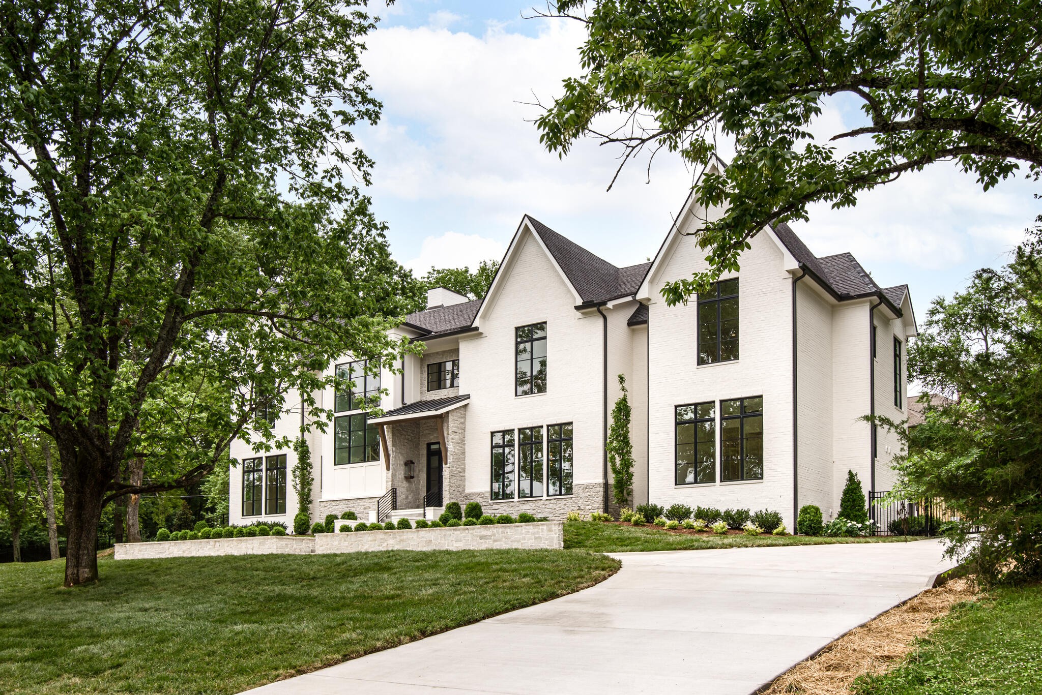 1401 Burton Valley Road Nashville, TN 37215 - Photo 2 of 68 a view of a white house with a big yard and large trees
