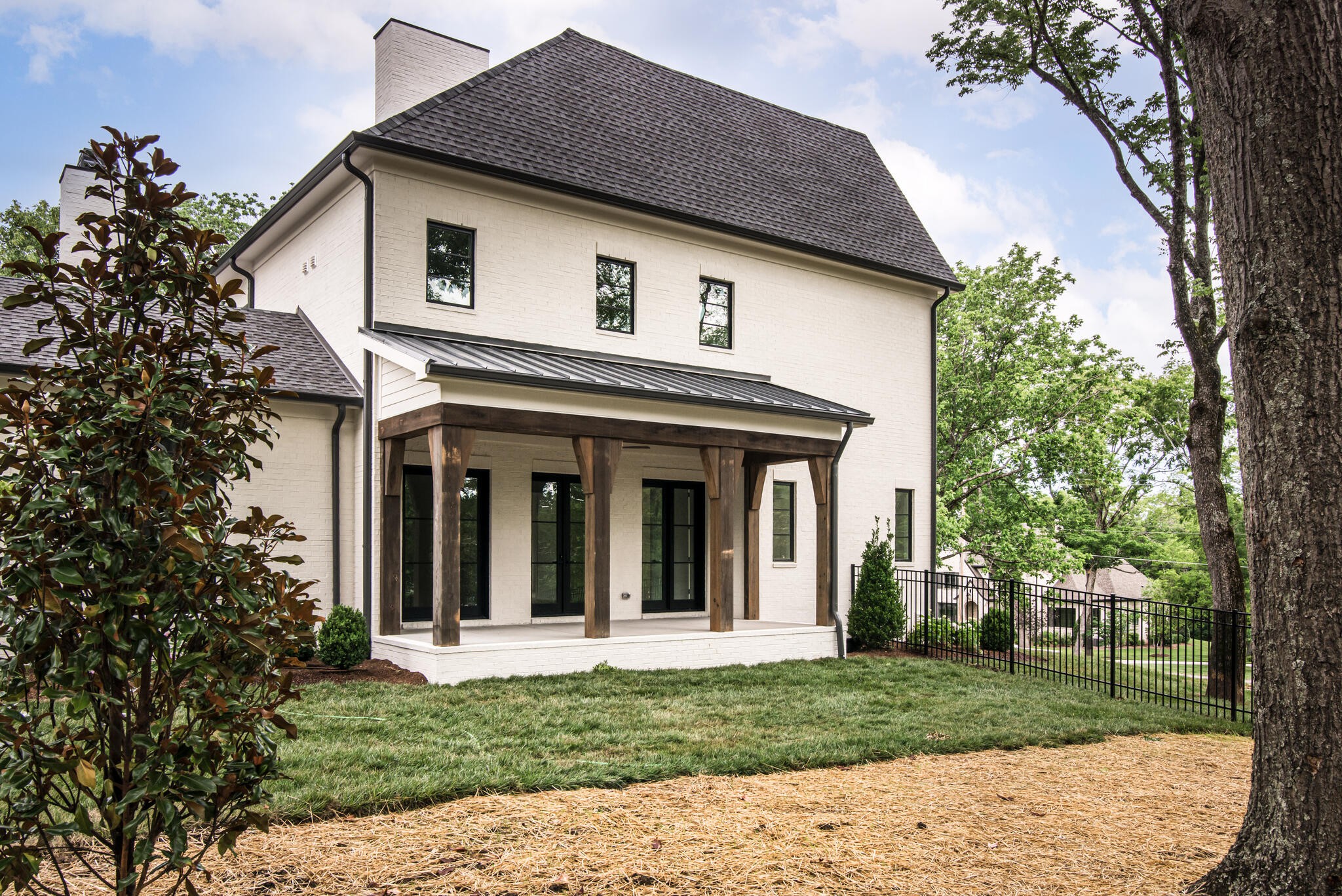 1401 Burton Valley Road Nashville, TN 37215 - Photo 66 of 68 a view of a white house with a small yard plants and a large tree