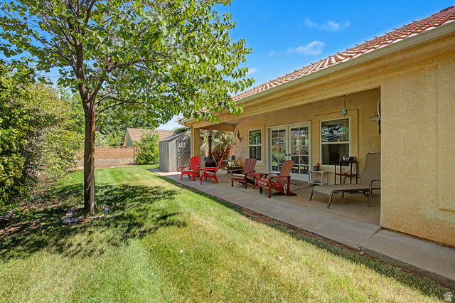 3034 Swiss Drive Santa Clara, UT 84765 - Photo 38 of 59 Expansive backyard featuring a manicured lawn, established tree, and concrete patio