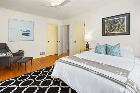 a bedroom with bed and wooden floor