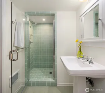 a bathroom with a sink shower and a mirror