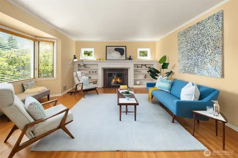 a living room with furniture a fireplace and a large window
