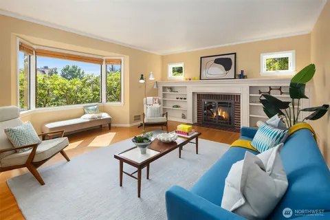 a living room with furniture a fireplace and a floor to ceiling window