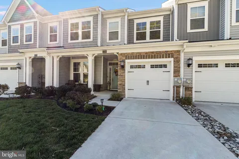 a kitchen with stainless steel appliances a refrigerator a stove a sink dishwasher with a dining table and chairs with wooden floor