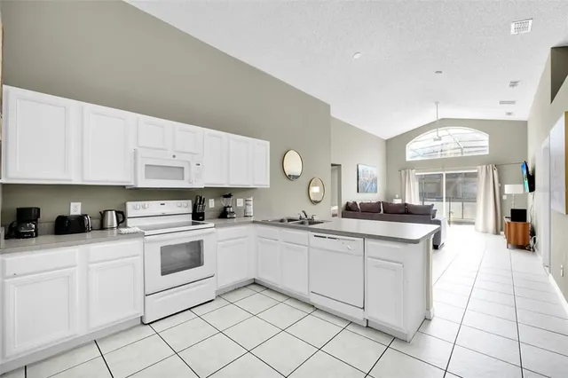 a kitchen with white cabinets appliances and a sink