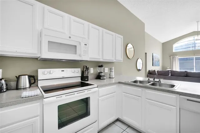 a kitchen with white cabinets stainless steel appliances and sink