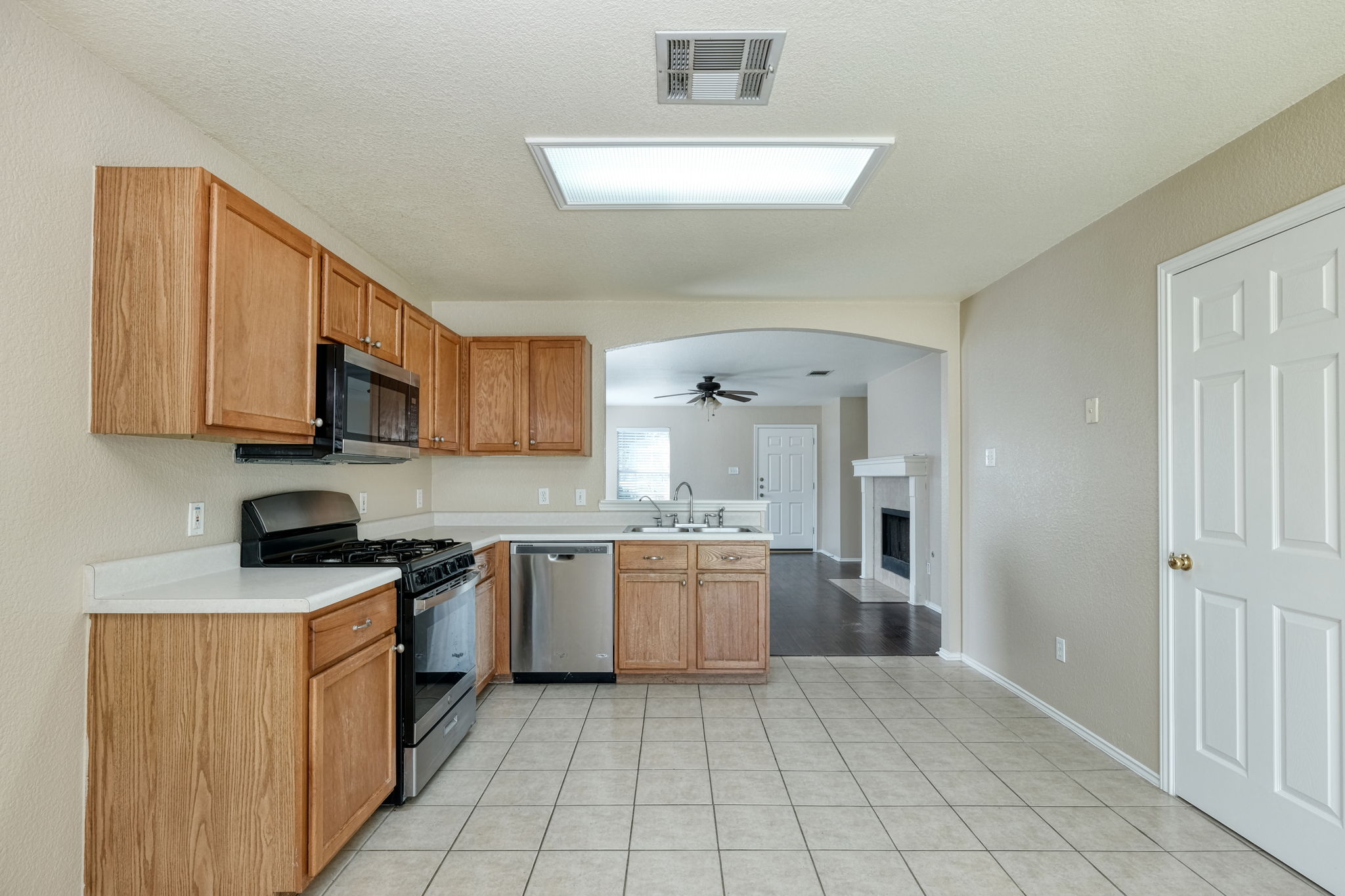 124 Hunter Rex Way Kyle, TX 78640 - Photo 5 of 14 Kitchen featuring wood-finish cabinetry, white countertops, and stainless steel appliances