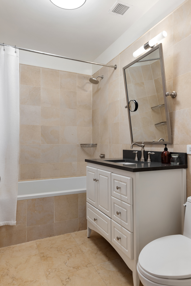 42 East 20th Street, Unit 7A Manhattan, NY 10003 - Photo 12 of 13 a bathroom with a granite countertop sink a toilet and a bathtub