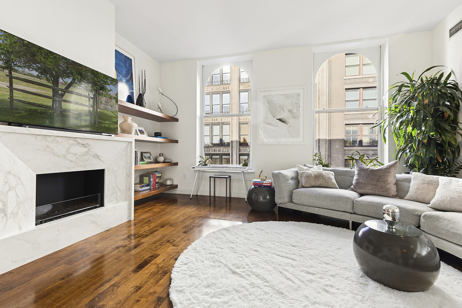 42 East 20th Street, Unit 7A Manhattan, NY 10003 - Photo 7 of 13 a living room with furniture a fireplace and a large window