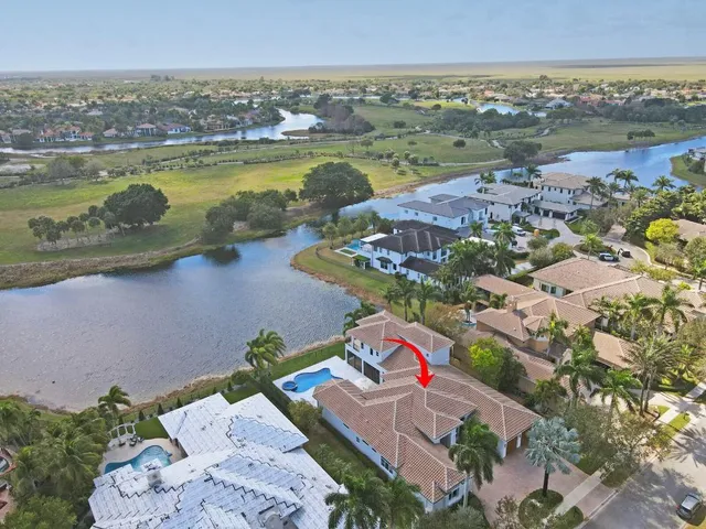 an aerial view of ocean and residential houses with outdoor space