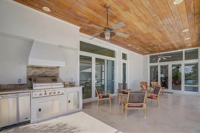 a kitchen with stainless steel appliances kitchen island granite countertop a table and chairs in it