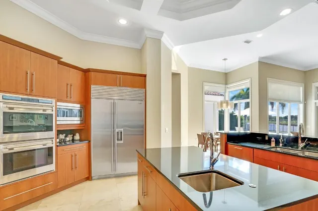 a kitchen with stainless steel appliances granite countertop a sink and a refrigerator