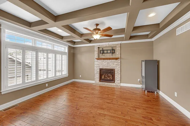 a view of an empty room with a fireplace and a window