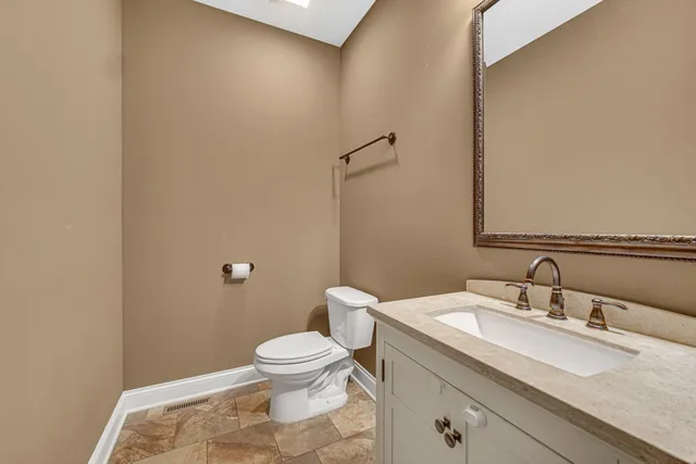 a bathroom with a granite countertop sink a toilet and a mirror