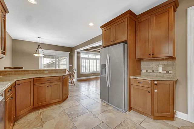a kitchen with stainless steel appliances granite countertop a refrigerator and a stove top oven