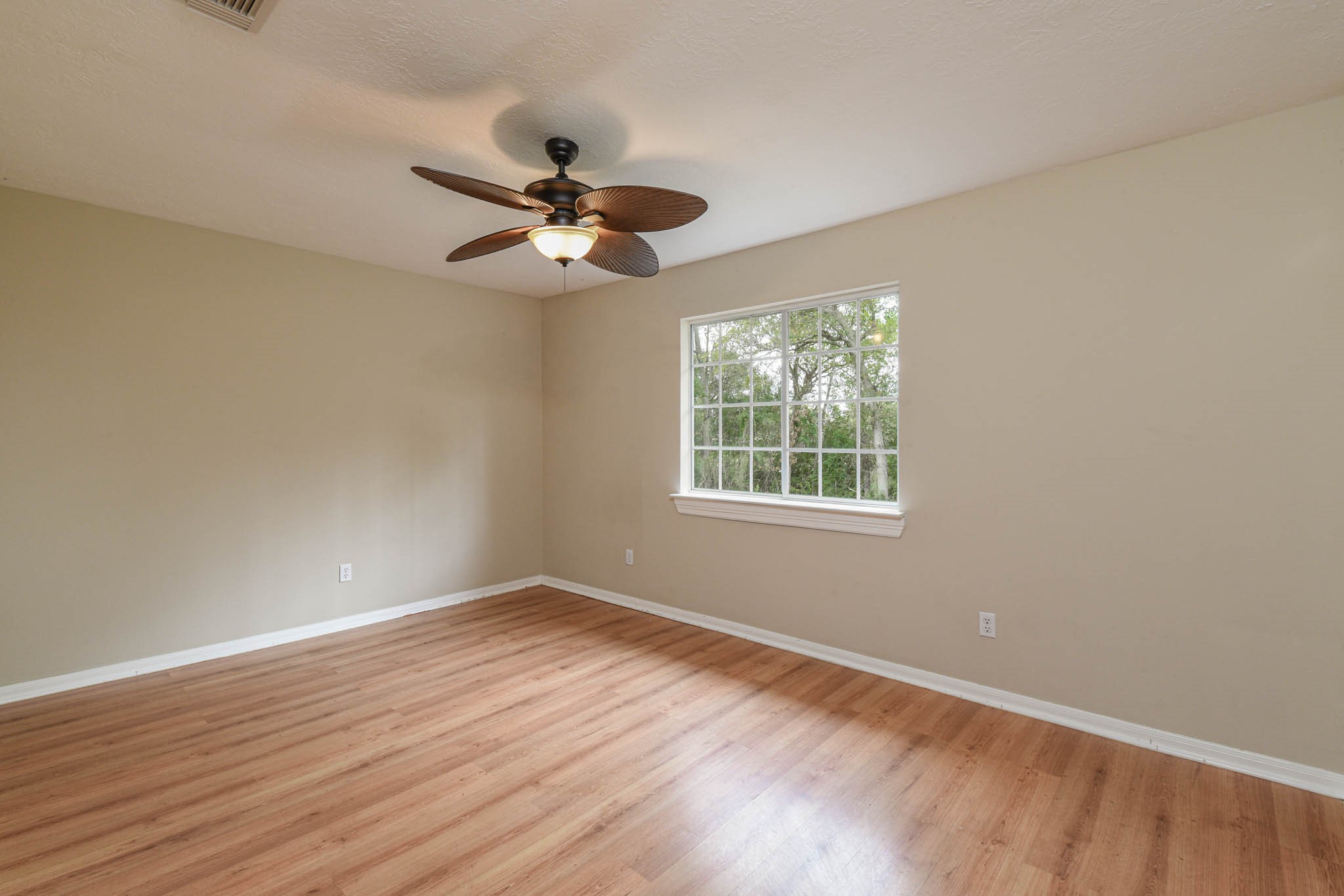 8806 Edenbridge Street Spring, TX 77379 - Photo 9 of 25 a view of empty room with wooden floor and fan