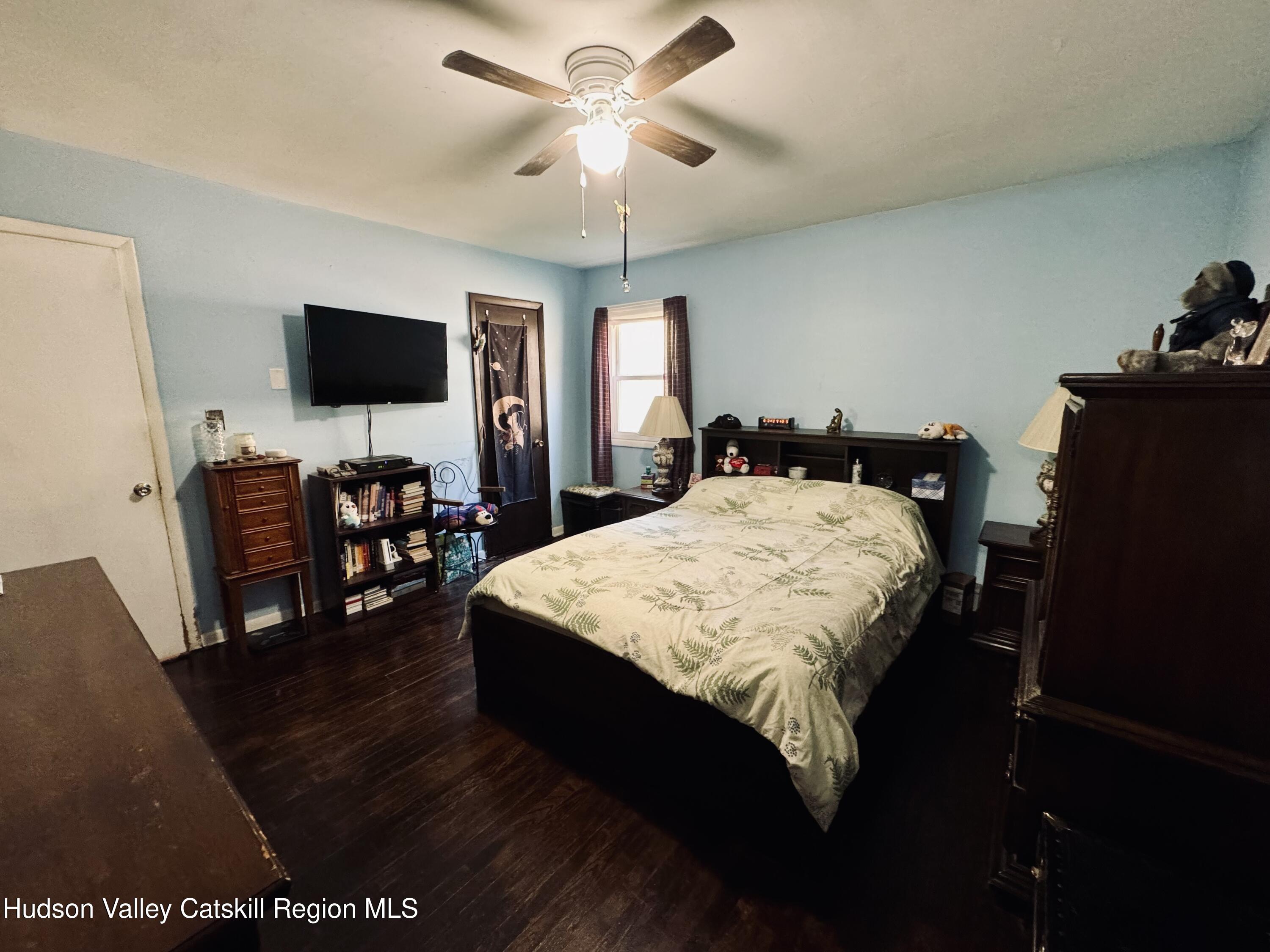 322 Plattekill Ardonia Road Wallkill, NY 12589 - Photo 14 of 22 a bed sitting in a bedroom next to a window with a flat screen tv and a chandelier