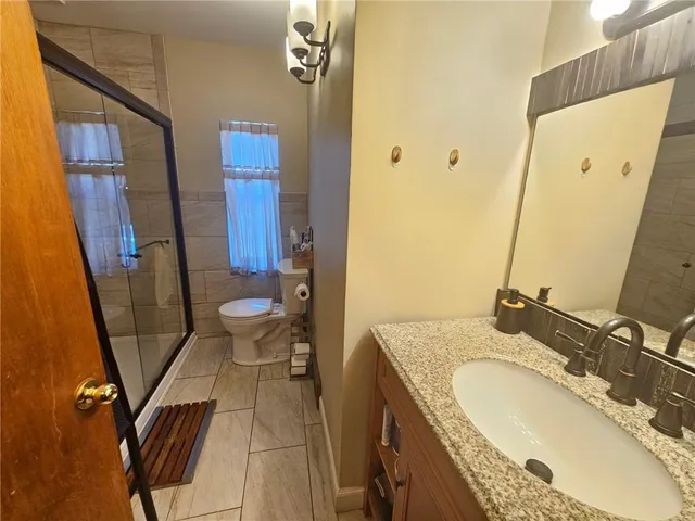 a bathroom with a granite countertop sink toilet and shower