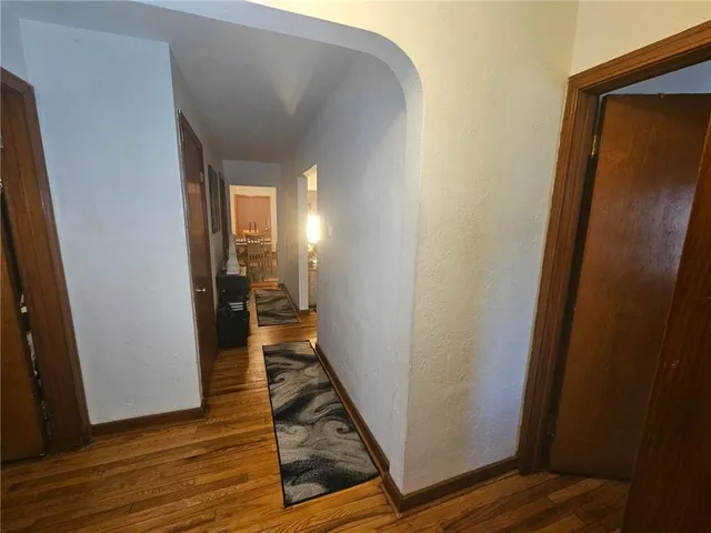 a view of a hallway with wooden floor and a living room