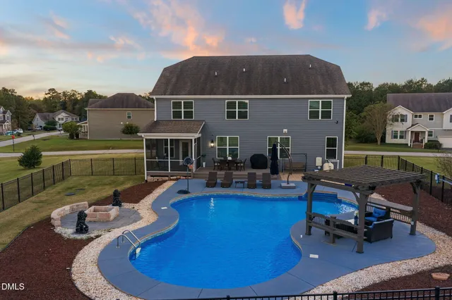 a view of a house with swimming pool and furniture